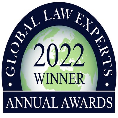 Round dark blue seal featuring a stylized globe, the inscription “2022 WINNER,” and the text “GLOBAL LAW EXPERTS ANNUAL AWARDS.”