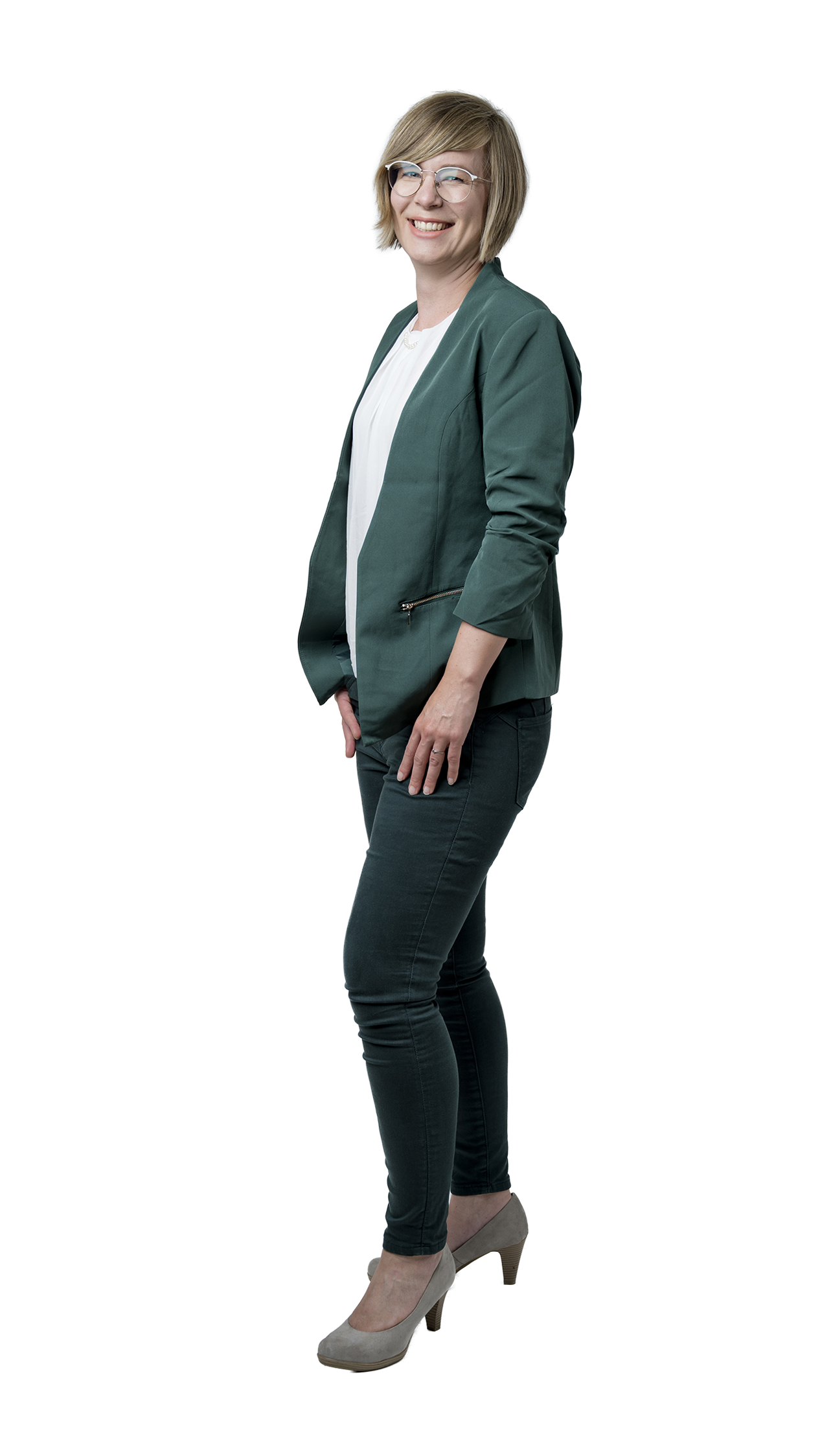 Ganzkörperporträt einer lächelnden Frau mit Brille, kurzem blondem Haar, grünem Blazer, weißer Bluse, dunkler Hose und grauen Pumps.