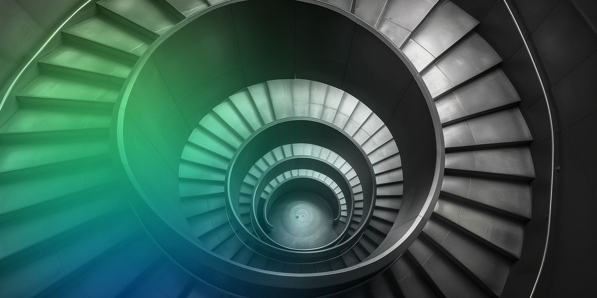 Top-down view of a spiral staircase with gray steps and green-blue lighting.